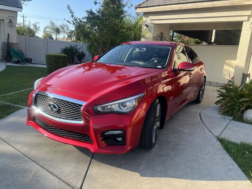 Red Infiniti Q50, front three-quarter, deep gloss